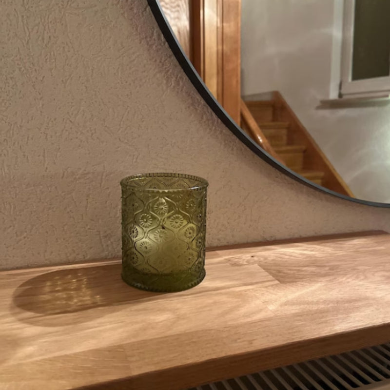 Nahaufnahme eines gemusterten Glas-Windlichts auf Heizkörperregal aus Eiche